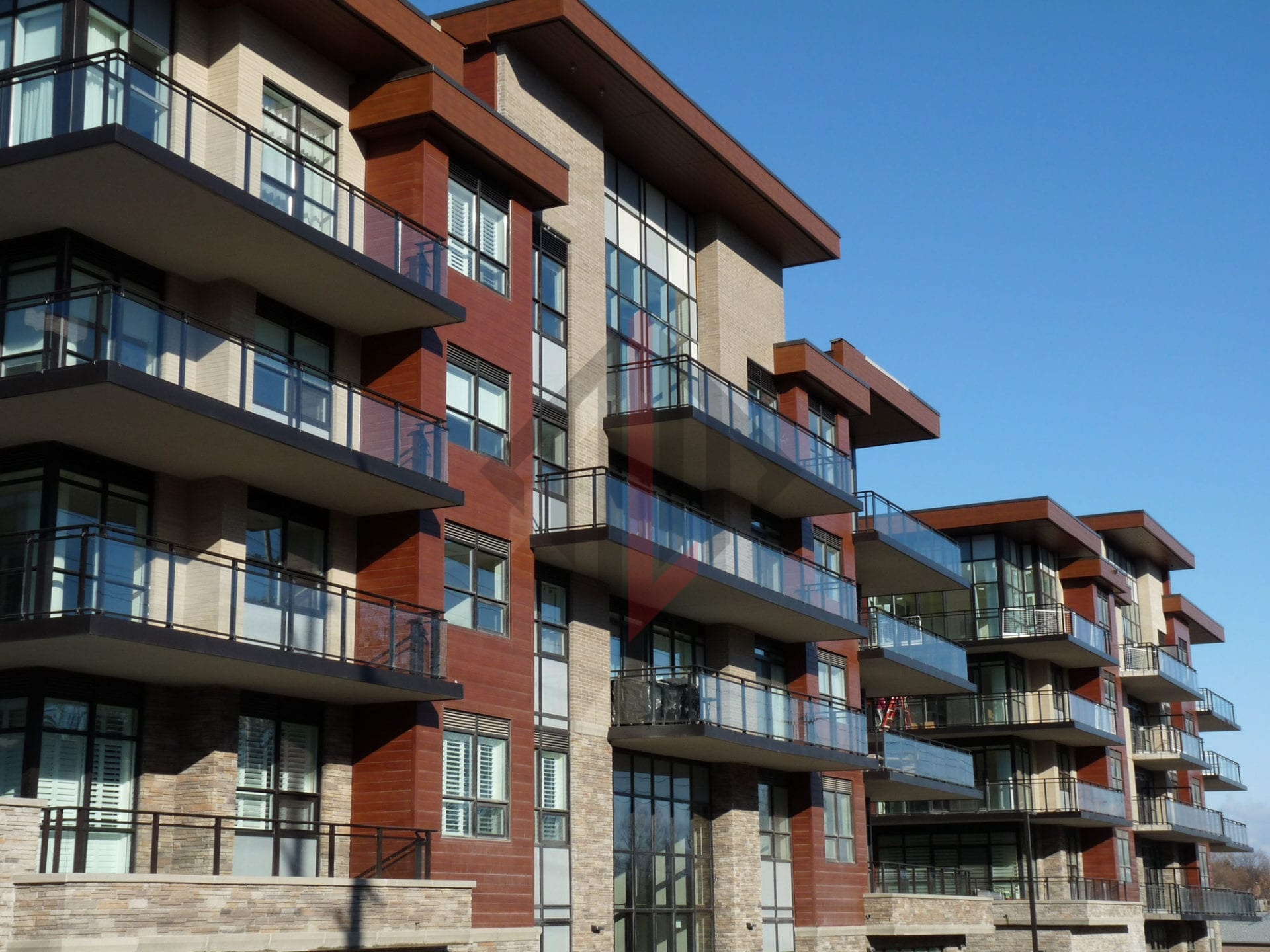 Modern apartment building with balconies under a clear blue sky.